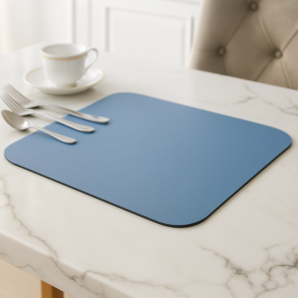 Microvezel afdruipmat op een marmeren aanrecht met servies en bestek erop.